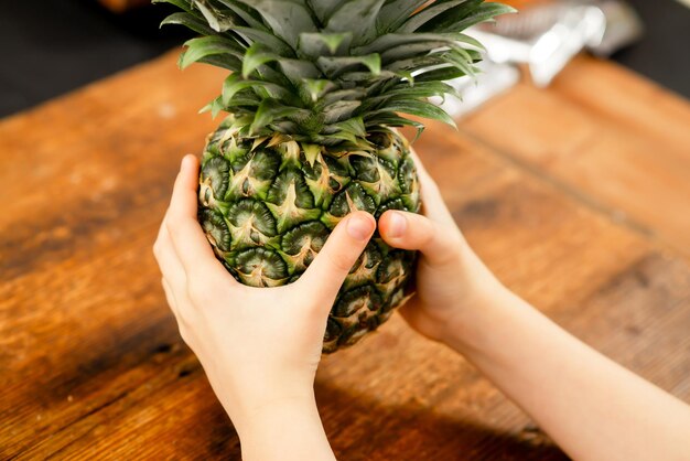 Il paradiso dell'ananas Le mani di un bambino cullano un ananas completo Un tesoro tropicale