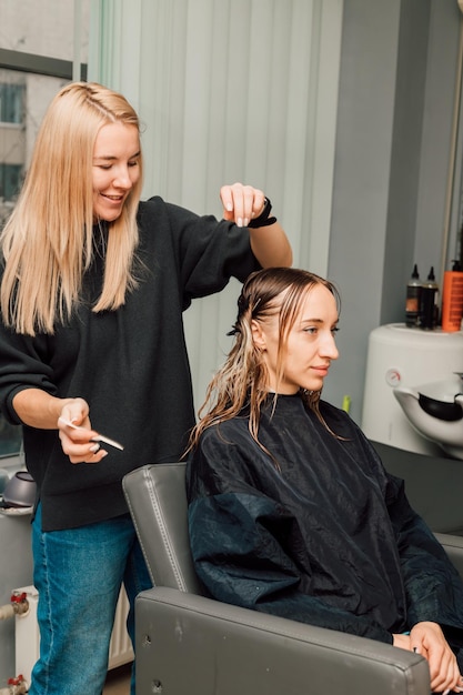 Il parrucchiere separa le ciocche di capelli con un pettine sulla testa dei clienti