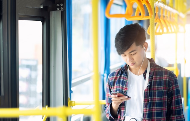 Il passeggero che utilizza il telefono cellulare sul bus pubblico.