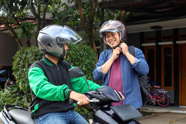 Il passeggero del taxi moto taxi online sta usando il casco prima della corsa