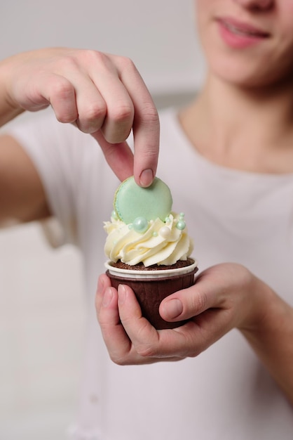 Il pasticcere decora il muffin con crema al burro e amaretti