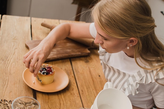 Il pasticcere della donna in grembiule decora il dessert