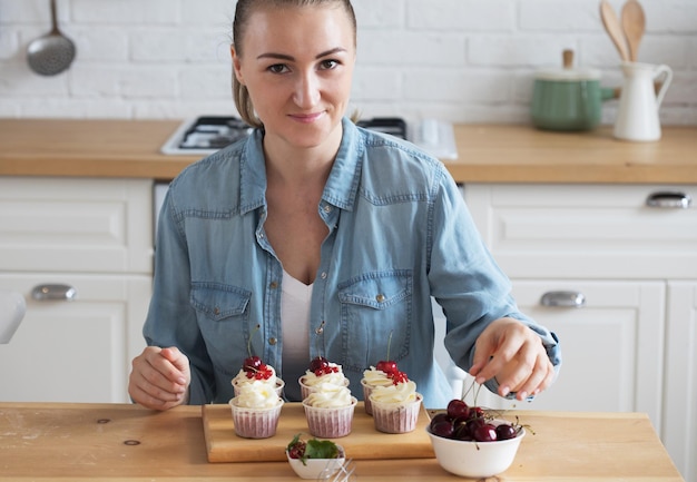 Il pasticcere della giovane donna decora i cupcakes