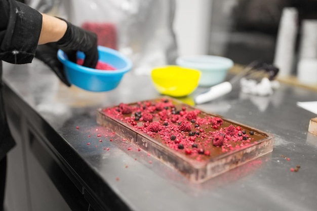 il pasticciere fa il dessert al cioccolato al negozio di dolci