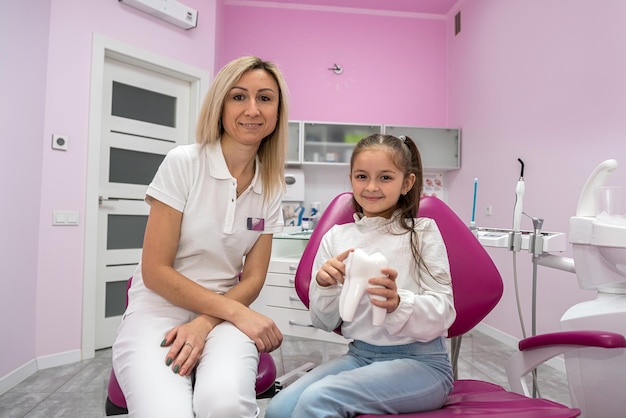 Il paziente si siede sulla poltrona del dentista dove il dentista le dice come lavarsi correttamente i denti