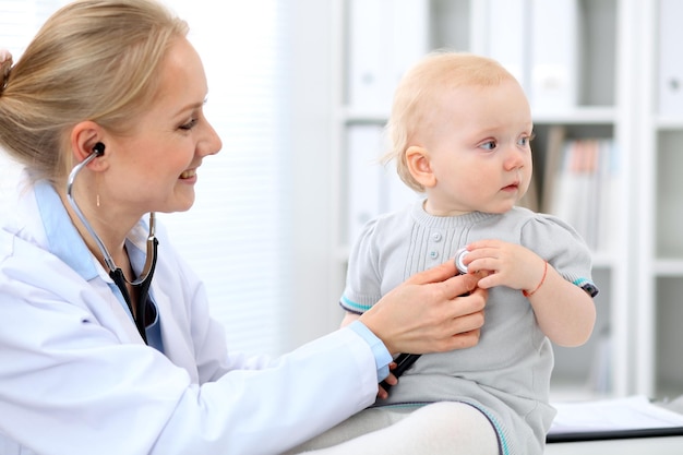 Il pediatra si prende cura del bambino in ospedale La bambina viene esaminata dal medico con lo stetoscopio Assicurazione sanitaria e concetto di aiuto