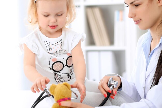 Il pediatra si prende cura del bambino in ospedale La bambina viene esaminata dal medico con lo stetoscopio Assicurazione sanitaria e concetto di aiuto