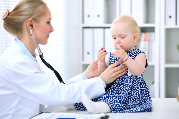 Il pediatra si prende cura del bambino in ospedale. La bambina viene esaminata dal medico con lo stetoscopio. Assistenza sanitaria, assicurazione e concetto di aiuto.