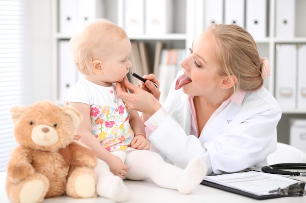 Il pediatra si prende cura del bambino in ospedale. La bambina viene esaminata dal medico con lo stetoscopio. Assistenza sanitaria, assicurazione e concetto di aiuto.