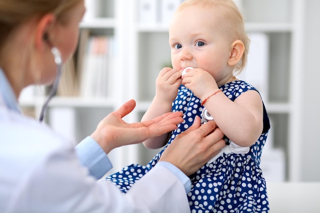 Il pediatra si prende cura del bambino in ospedale. La bambina viene esaminata dal medico con lo stetoscopio. Assistenza sanitaria, assicurazione e concetto di aiuto.