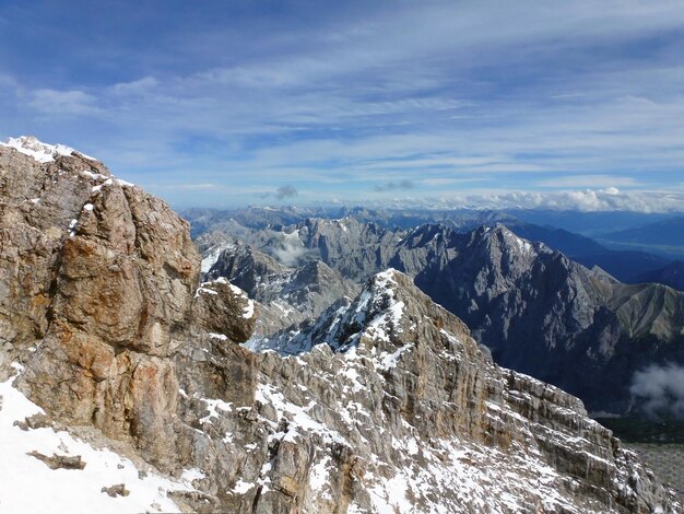 Il pendio di una montagna rocciosa innevata sullo sfondo di un cielo azzurro Un inverno meraviglioso