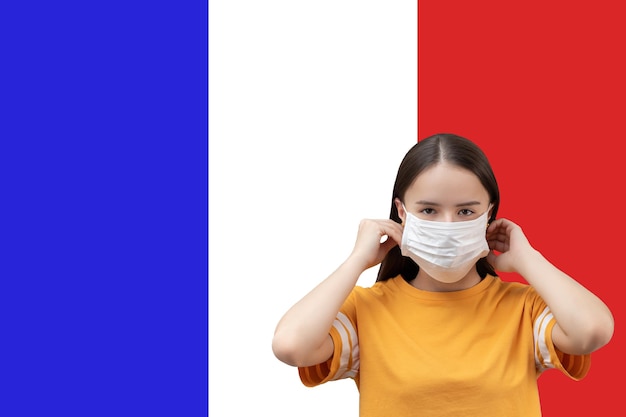 Il pericolo del coronavirus in Francia Giovane ragazza con maschera medica antibatterica su sfondo bandiera con copyspace