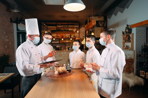 Il personale del bar durante il briefing mattutino indossa maschere protettive