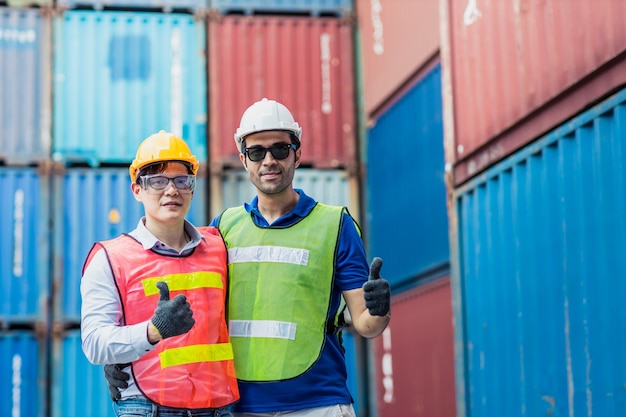 Il personale e il caposquadra controllano il carico di container cargo team di lavoro felice godere di lavorare in piedi sorriso mano mostra i pollici in su.