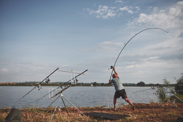 Il pescatore lancia un'esca con esca. Oggi prenderà un grosso pesce. Caccia e sport per hobby