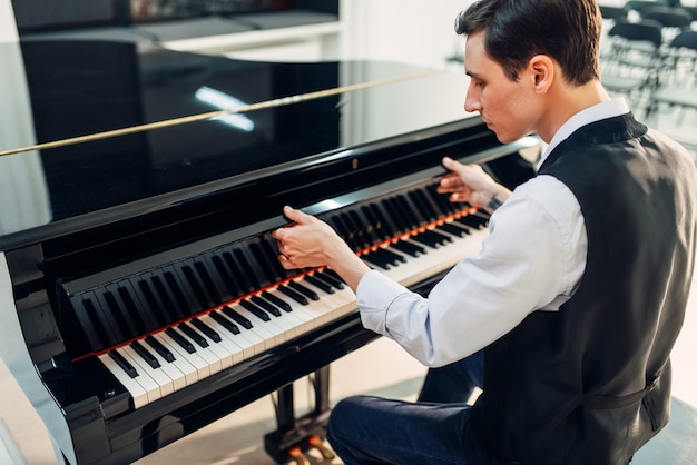 Il pianista apre il coperchio della tastiera del pianoforte a coda