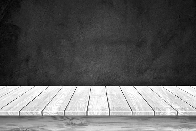 Il piano del tavolo in legno bianco e lo sfondo nero della parete possono essere utilizzati per visualizzare o montare i tuoi prodotti