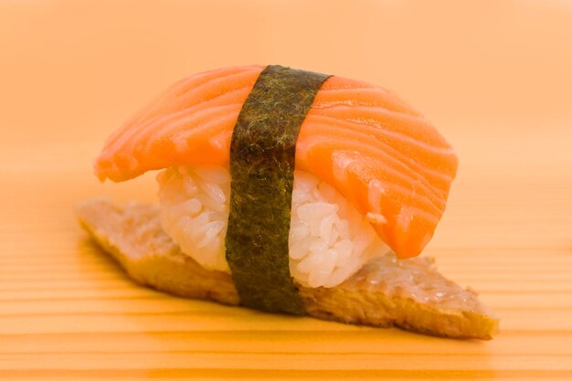 Il piatto giapponese che mangia il sushi con le bacchette su un piatto è allineato