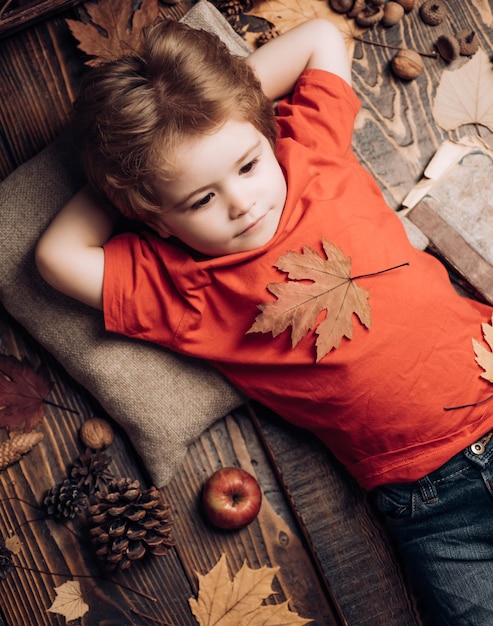 Il piccolo bambino carino si sta preparando per l'autunno Il bambino piccolo giace su una calda coperta sogna di...