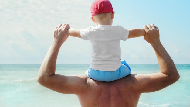 Il piccolo figlio e padre guarda il mare