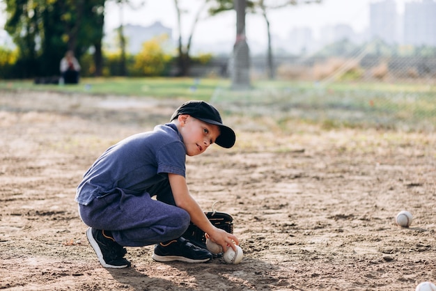 il piccolo giocatore di baseball sta aspettando una posizione