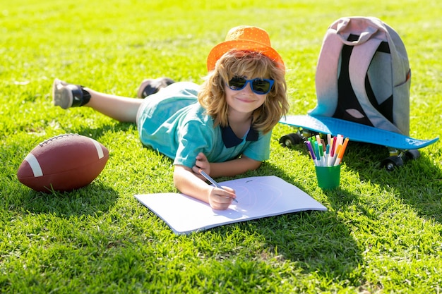 Il pittore del bambino attinge al parco giochi l'artista del bambino dipinge la creatività il ragazzo del bambino di vacanza disegna nel parco layin