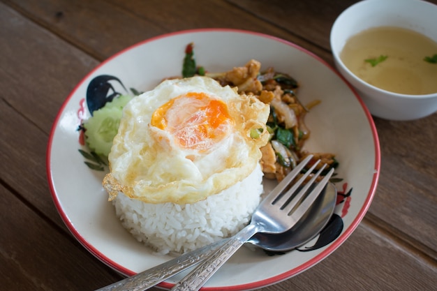 Il pollo fritto e il basilico tailandese servito con riso e uovo fritto, il cibo preferito dalla Thailandia.