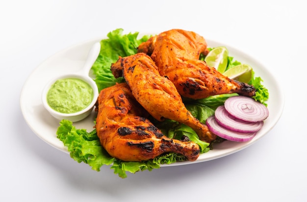 Il pollo tandoori è un piatto di pollo preparato arrostendo il pollo marinato in yogurt e spezie in un tandoor o in un forno di argilla, servito con cipolla e chutney verde