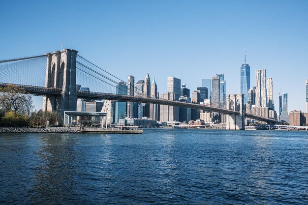 Il ponte di Brooklyn da Pebble Beach all'ora d'oro con l'intero skyline di Brooklyn