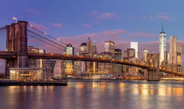 Il ponte di Brooklyn e i grattacieli di Manhattan all'ora dell'alba bellissimi colori delicati del cielo e delle illuminazioni della città New York USA