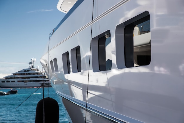 Il ponte superiore di un enorme yacht in una giornata di sole, bordo lucido della barca, il corrimano cromato, il megayacht è ormeggiato in porto, riflesso del sole su bordo lucido. Foto di alta qualità