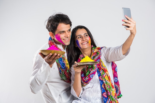 Il popolo indiano celebra l'holi con il dolce laddu, i colori in thali e gli schizzi di colore