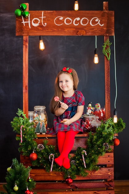 Il portrai di una bella bambina vicino natale decorati con lillypop