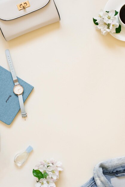 Il posto di lavoro di una blogger donna Una giacca di jeans scarpe da ginnastica una tazza di caffè una macchina fotografica un orologio da polso e un taccuino con una penna sullo sfondo con una posizione di copia