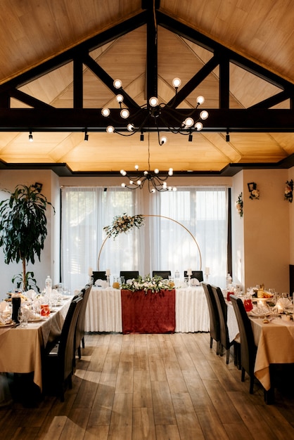 Il presidio degli sposi nella sala banchetti del ristorante è addobbato con candele e piante verdi, dal soffitto pende il glicine