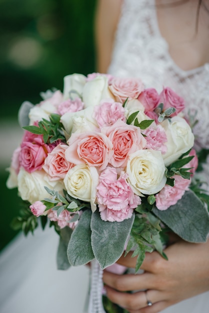 Il primo piano bello e sofisticato del mazzo di nozze tiene la sposa in sue mani. Bouquet da sposa.