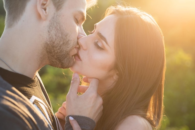 Il primo piano della giovane coppia romantica sta baciando il profilo di belle persone innamorate che si esprimono e affec