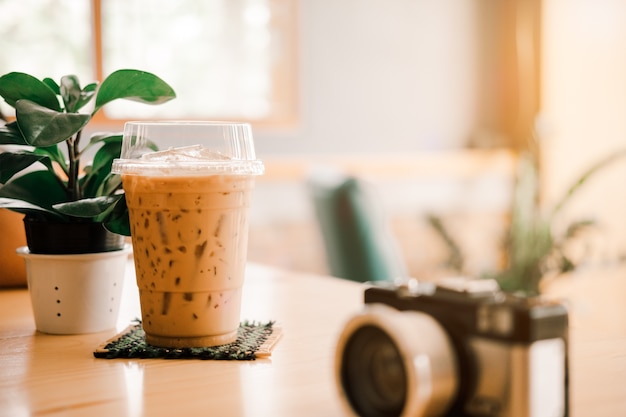 Il primo piano della macchina fotografica ha un buon giorno con un fondo dei vasi della pianta e della tazza di caffè con luce solare