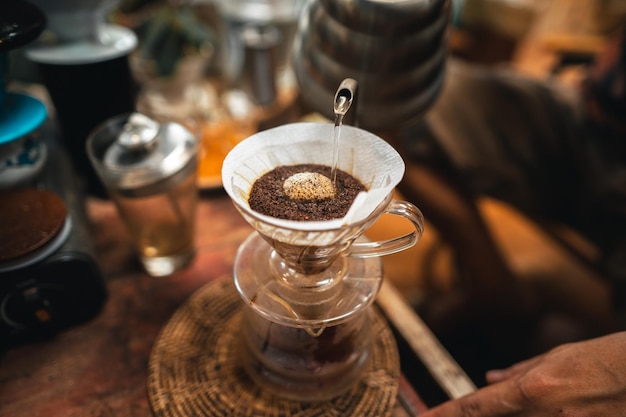 Il primo piano delle mani il barista prepara il caffè