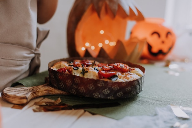 Il primo piano di una focaccia e una lanterna di zucca sono sullo spazio del concetto di halloween del tavolo per il testo