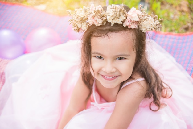 Il primo piano ha sparato del fiore della corona da portare della bambina che sorride nel parco