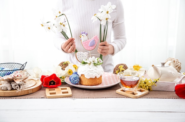 Il processo di decorazione di una composizione con la torta pasquale. Il concetto di arredamento per le vacanze di Pasqua.