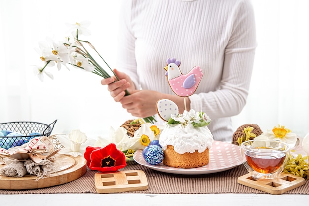 Il processo di decorazione di una composizione con la torta pasquale. Il concetto di arredamento per le vacanze di Pasqua.