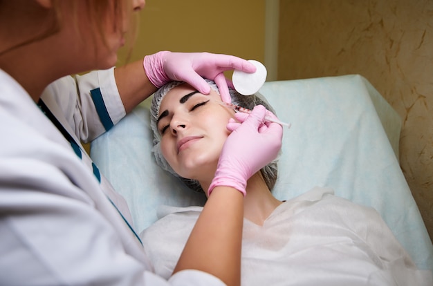 Il processo di iniezione del farmaco di fronte alla ragazza sdraiata