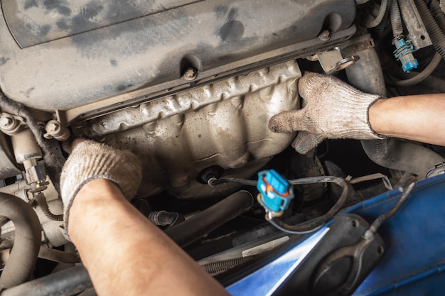 Il processo di installazione della protezione del collettore sul motore di un'auto un impiegato del servizio auto al lavoro