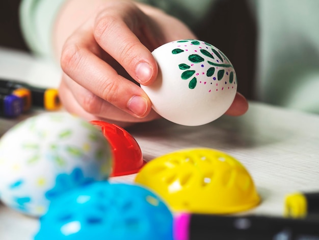 Il processo di pittura delle uova di Pasqua Le mani delle donne decorano le uova per Pasqua