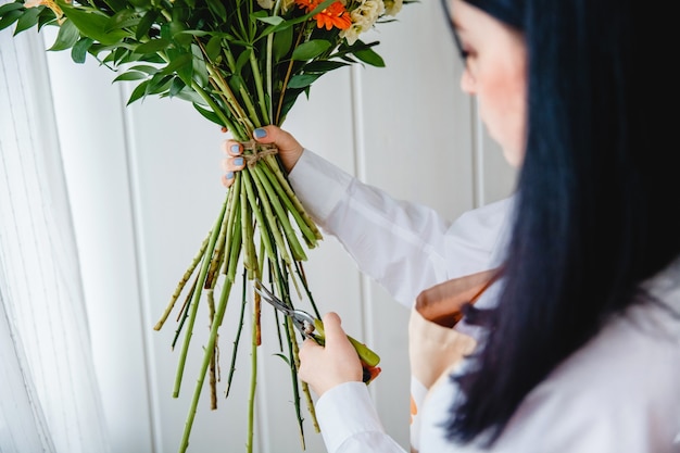 Il processo di potatura degli steli di un bouquet con cesoie da potatura