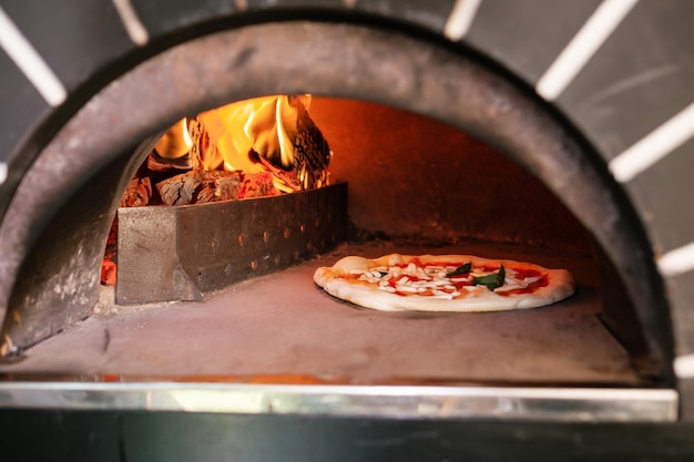 Il processo di preparazione della pizza Pizza italiana nel forno a legna La pizza italiana viene cotta nel forno a legna