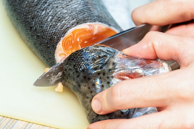 Il processo di taglio con un coltello trota, testa di pesce salmone