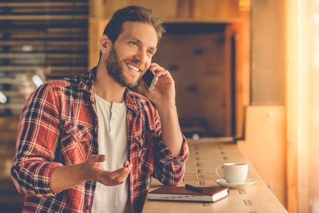 Il progettista bello sta parlando sul telefono cellulare